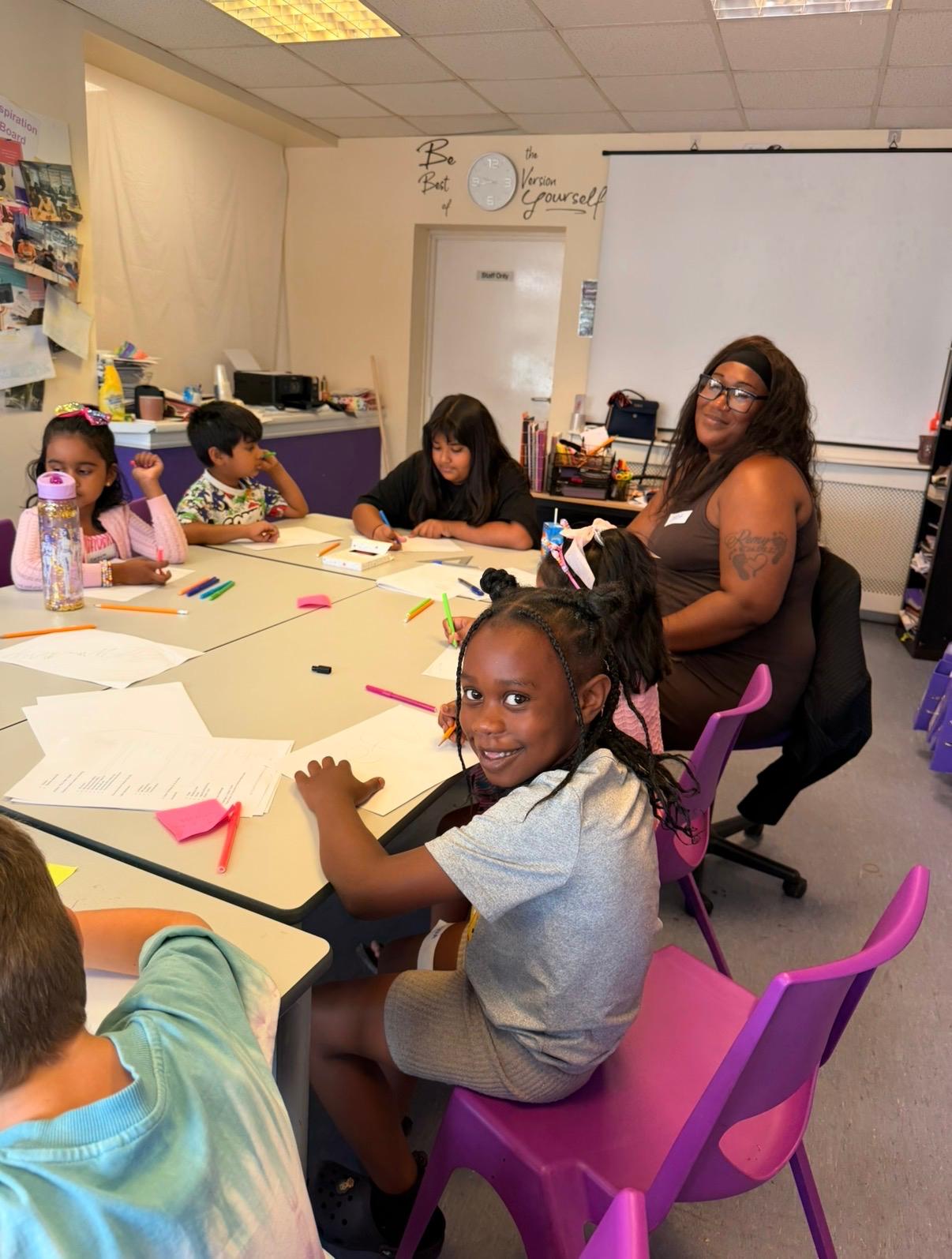 Children and an adult working together around a table