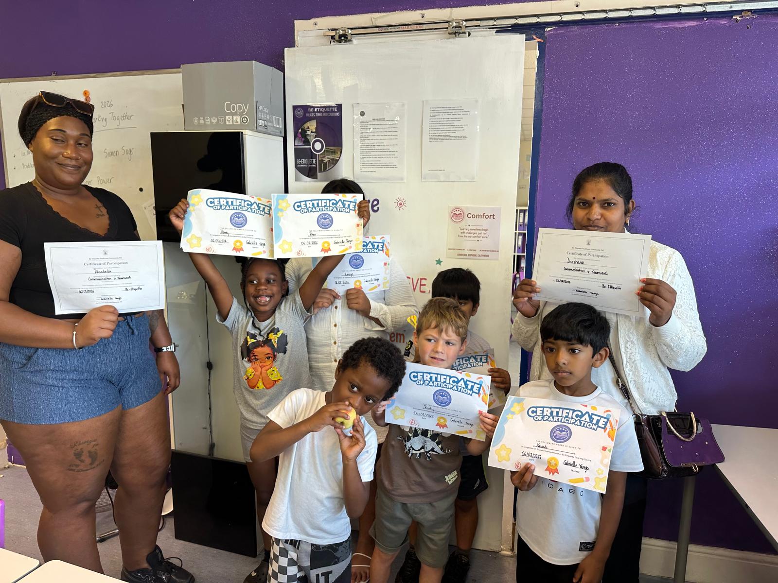 Children and parents holding Communication and Teamwork participation certificates