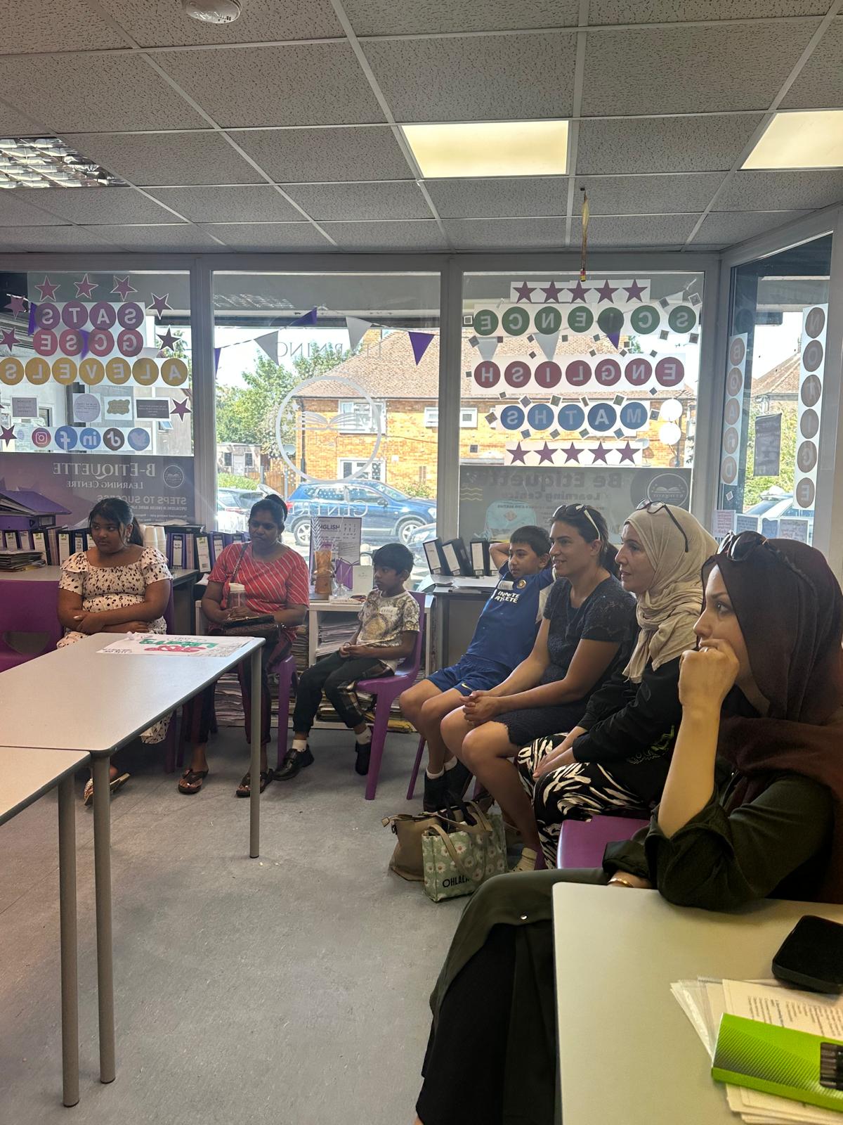 Parents and children seated together watching a presentation in the learning centre